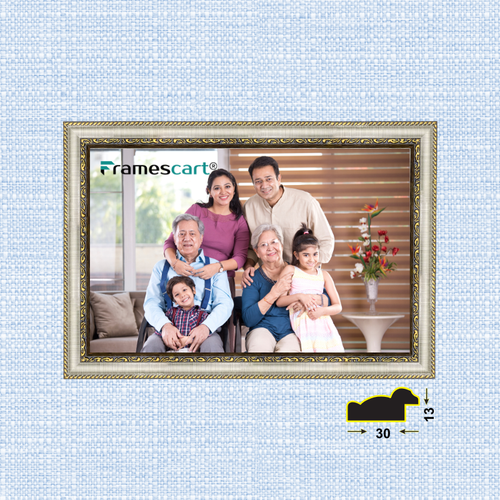 Framed family photo on a textured blue wall with 'Framescart' branding.