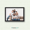 Framed family photo on a textured white wall with 'Framescart' branding.